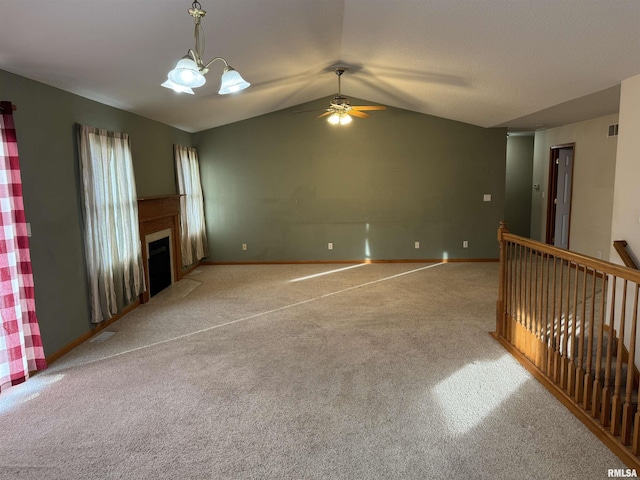 unfurnished living room with ceiling fan with notable chandelier, light colored carpet, and lofted ceiling