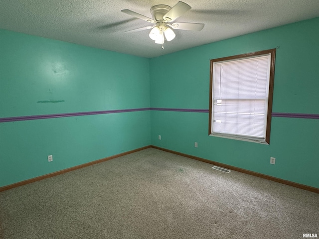 carpeted empty room with ceiling fan and a textured ceiling