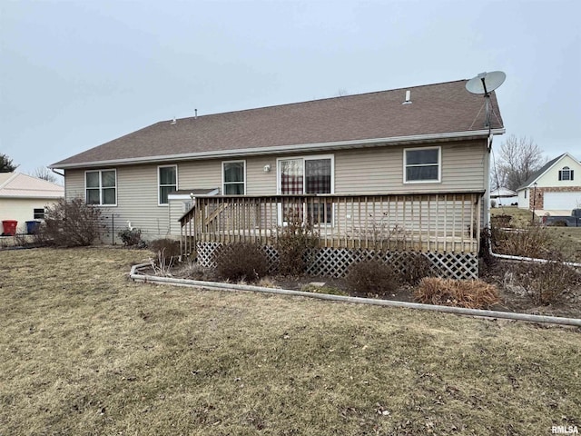 back of property featuring a deck and a lawn