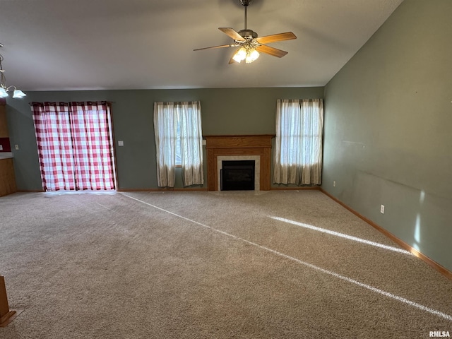 unfurnished living room with ceiling fan, carpet, vaulted ceiling, and a tiled fireplace