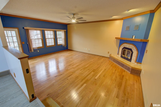 591 Breezy Point Dr, Clinton, IA 52732 - unfurnished living room with ceiling fan, ornamental molding, wood finished floors, healthy amount of natural light, and a textured ceiling
