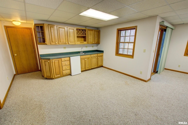 591 Breezy Point Dr, Clinton, IA 52732 - kitchen featuring a sink, dark countertops, baseboards, a paneled ceiling, and light colored carpet