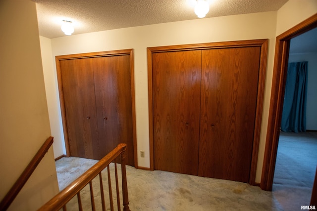 591 Breezy Point Dr, Clinton, IA 52732 - hall featuring carpet flooring, an upstairs landing, and a textured ceiling