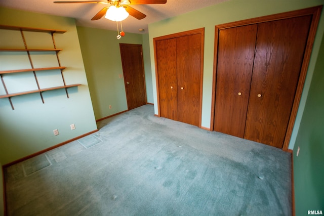 591 Breezy Point Dr, Clinton, IA 52732 - unfurnished bedroom with carpet floors, baseboards, multiple closets, and ceiling fan