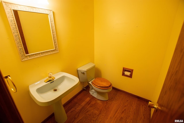 591 Breezy Point Dr, Clinton, IA 52732 - bathroom featuring wood finished floors, toilet, baseboards, and a sink