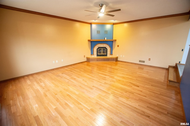 591 Breezy Point Dr, Clinton, IA 52732 - unfurnished living room featuring crown molding, a ceiling fan, wood finished floors, a large fireplace, and baseboards