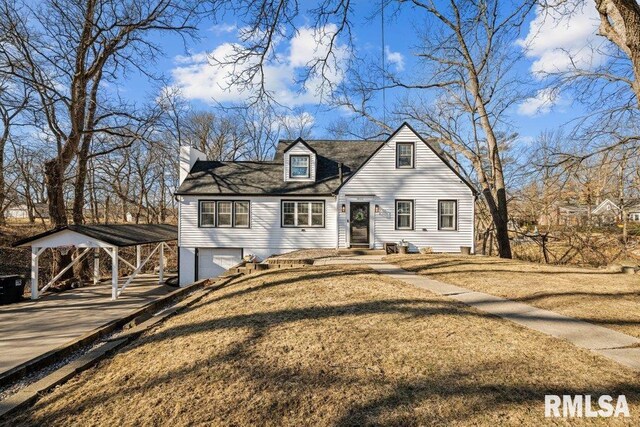 cape cod house with a garage, a front lawn, and a carport