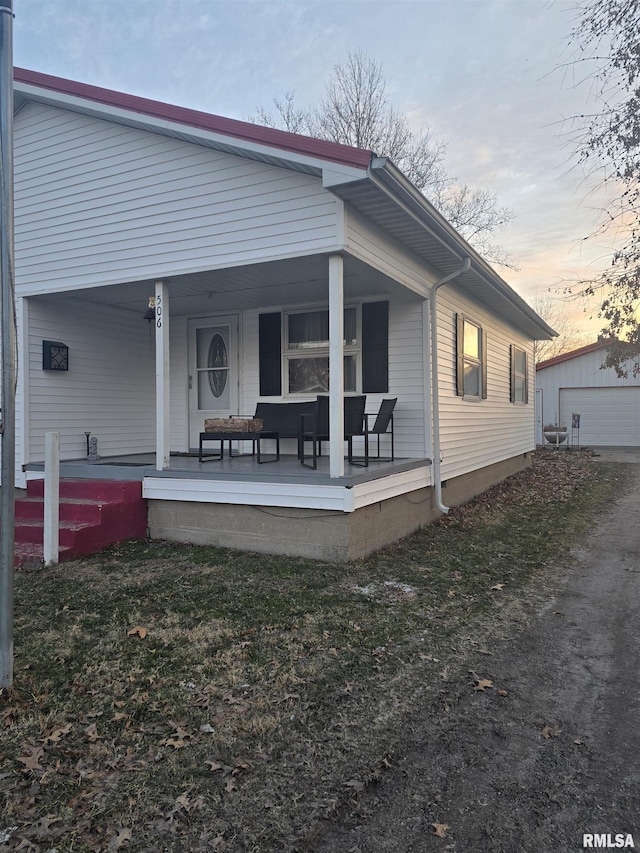 back house at dusk with covered porch