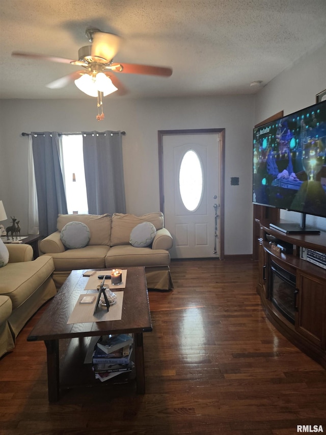 living room with ceiling fan, dark hardwood / wood-style floors, and a textured ceiling