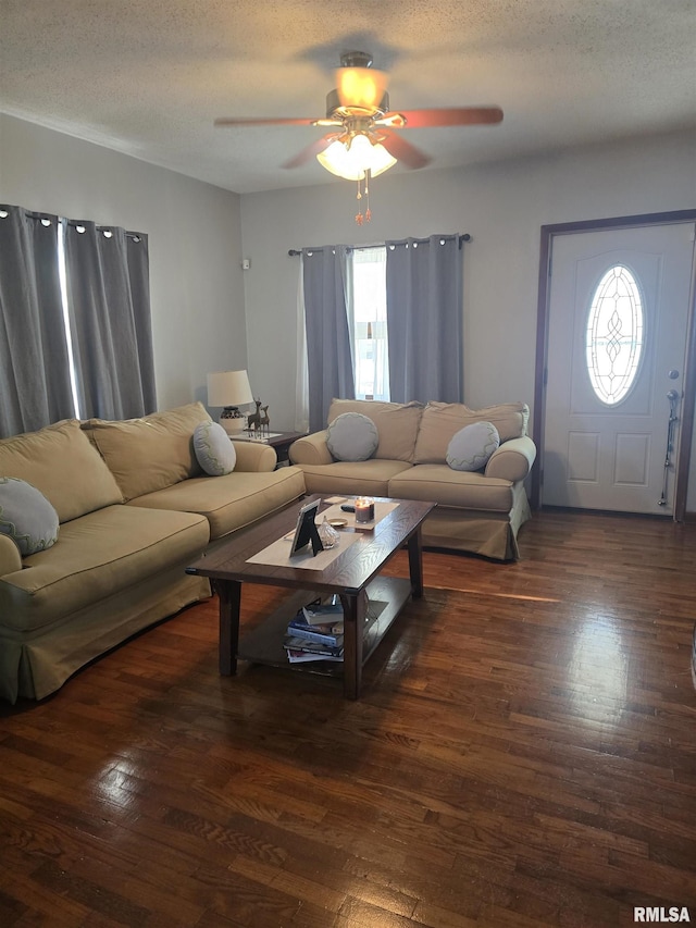 living room featuring ceiling fan, dark hardwood / wood-style floors, and a textured ceiling