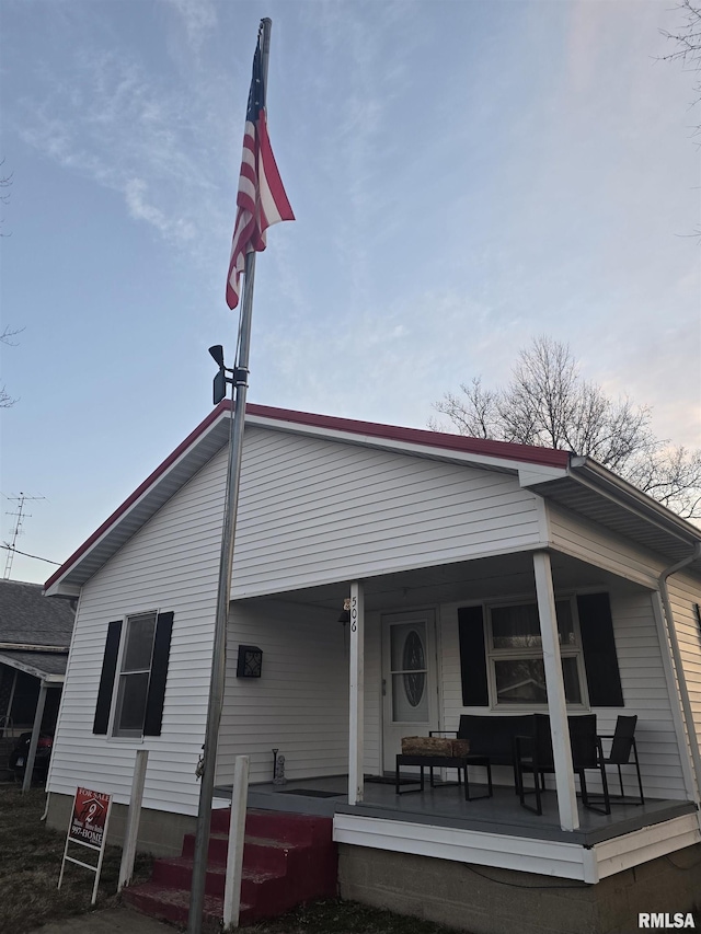 rear view of property with covered porch