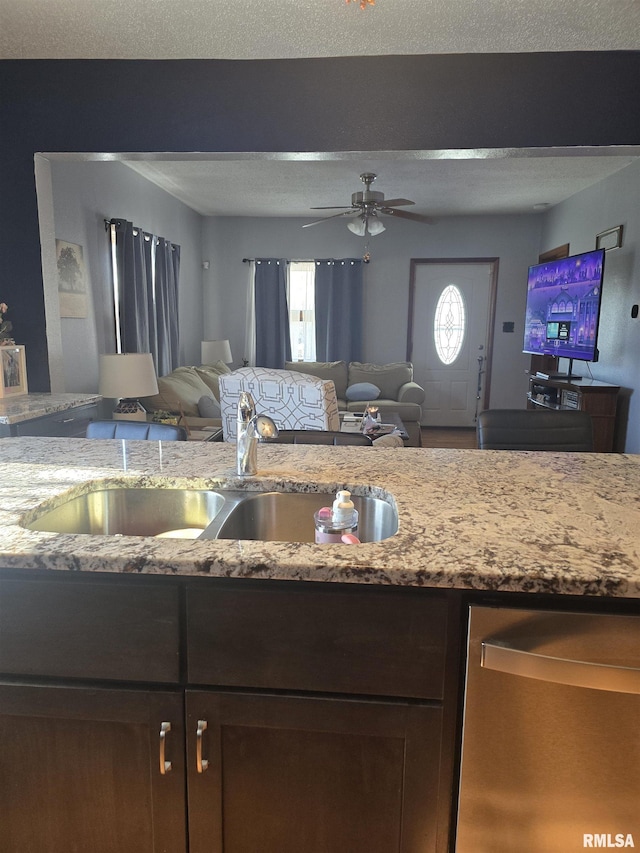 kitchen with light stone counters, sink, a wealth of natural light, and ceiling fan