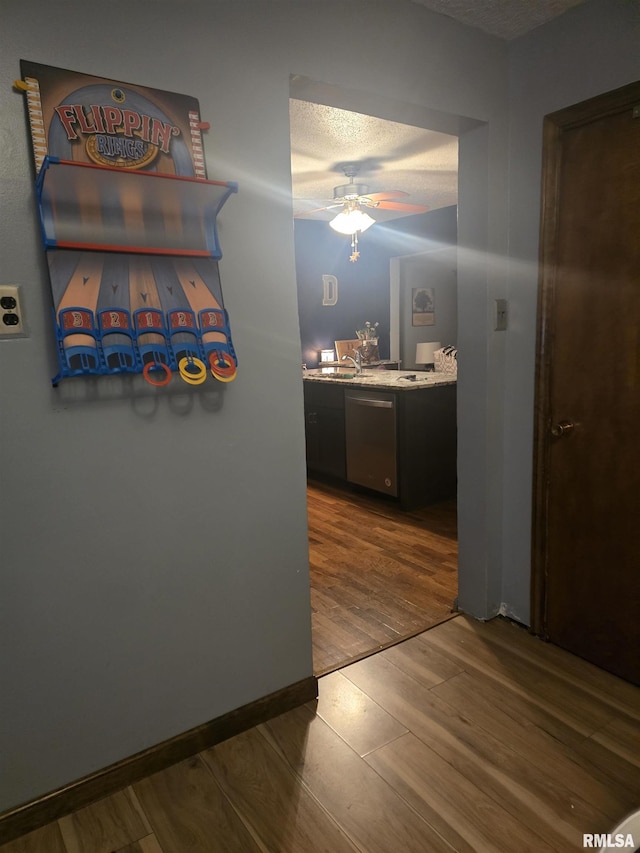 hall featuring sink, hardwood / wood-style floors, and a textured ceiling