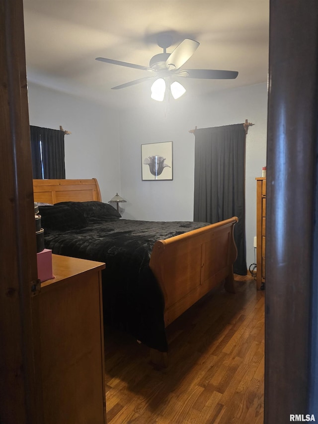 bedroom with dark hardwood / wood-style floors and ceiling fan