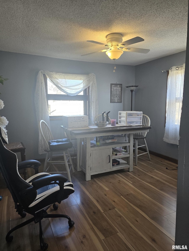 office area with ceiling fan, dark hardwood / wood-style floors, and a textured ceiling