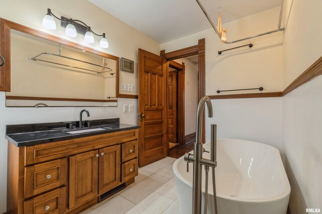 bathroom featuring a washtub, tile patterned floors, and vanity