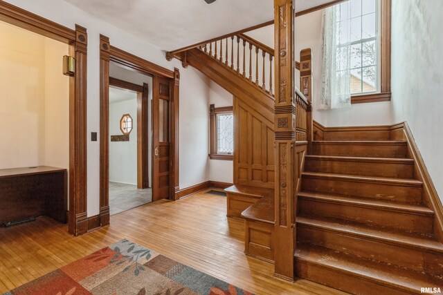 stairway with decorative columns and hardwood / wood-style flooring