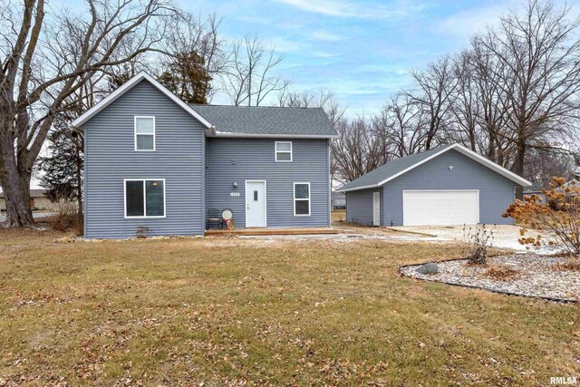 view of property featuring an outbuilding, a garage, and a front lawn