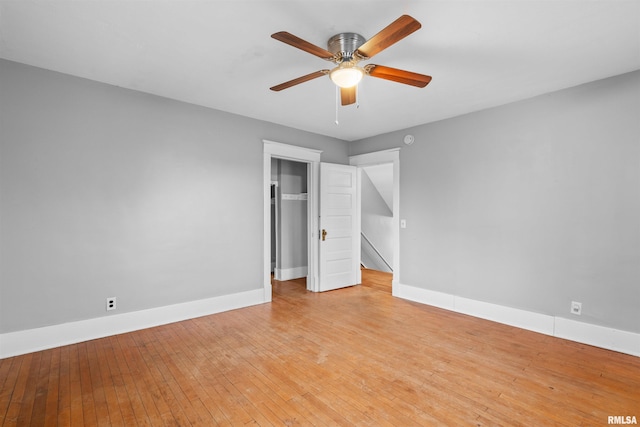 unfurnished bedroom featuring ceiling fan, light hardwood / wood-style floors, and a closet