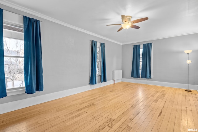 unfurnished room featuring ornamental molding, a wealth of natural light, ceiling fan, and light hardwood / wood-style flooring