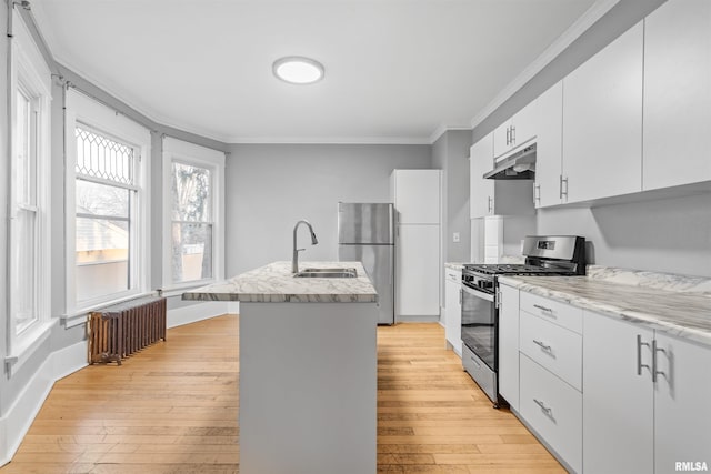 kitchen with radiator, crown molding, appliances with stainless steel finishes, light hardwood / wood-style floors, and white cabinets