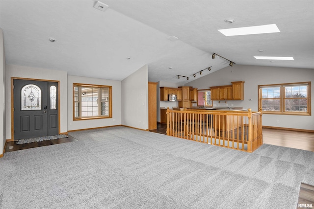 2260 260th Ave, De Witt, IA 52742 - carpeted foyer with vaulted ceiling, baseboards, a skylight, and plenty of natural light