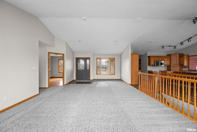 2260 260th Ave, De Witt, IA 52742 - unfurnished living room featuring baseboards, carpet floors, and vaulted ceiling