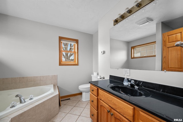 bathroom with tile patterned floors, toilet, vanity, and tiled tub