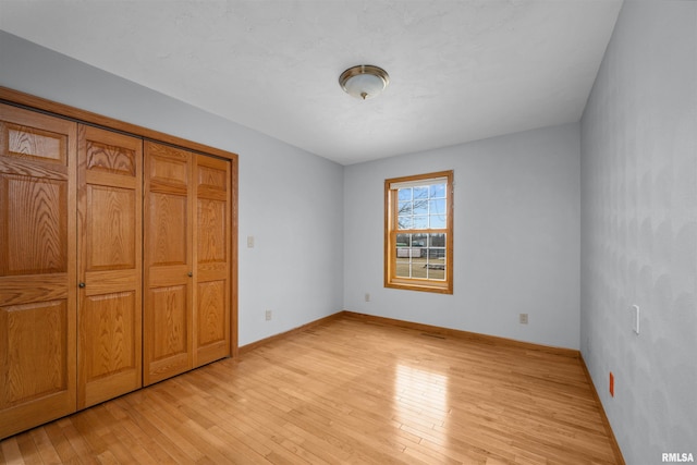 2260 260th Ave, De Witt, IA 52742 - unfurnished bedroom featuring light wood-style floors and baseboards