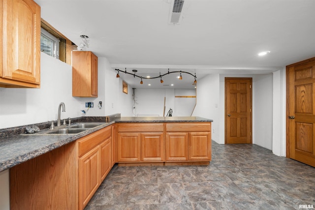 2260 260th Ave, De Witt, IA 52742 - kitchen with a sink, dark countertops, a peninsula, and brown cabinets