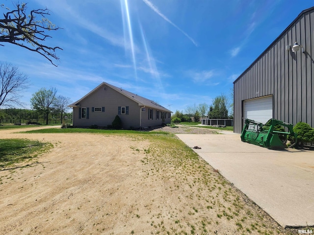 2260 260th Ave, De Witt, IA 52742 - view of home's exterior with board and batten siding and concrete driveway