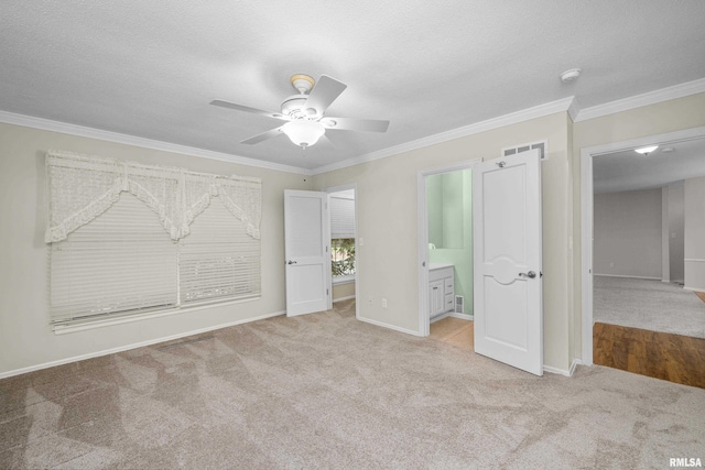 unfurnished bedroom with crown molding, light carpet, connected bathroom, and ceiling fan