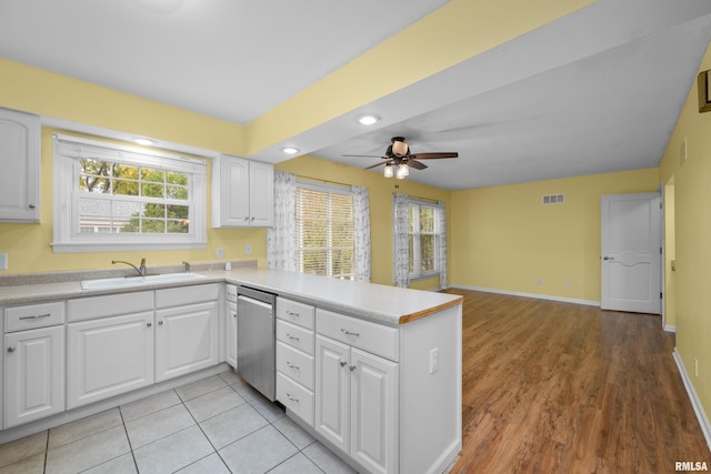 kitchen featuring dishwasher, sink, white cabinets, ceiling fan, and kitchen peninsula