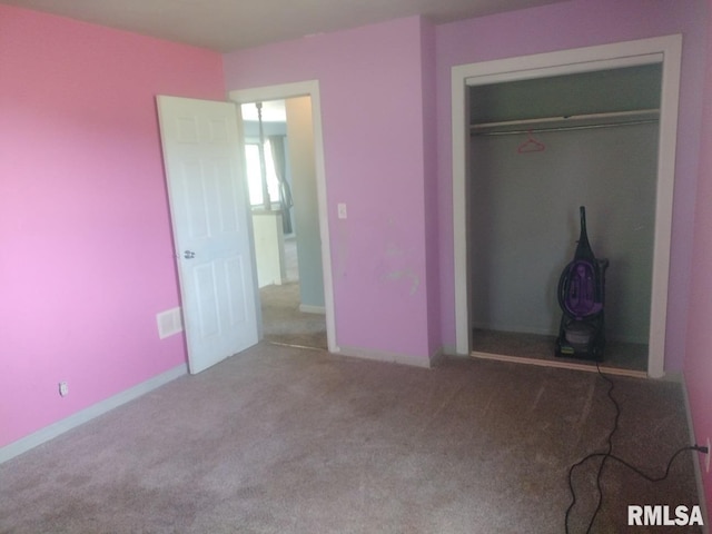 unfurnished bedroom with light colored carpet and a closet