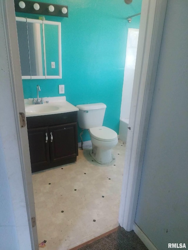 bathroom with a tub to relax in, vanity, and toilet