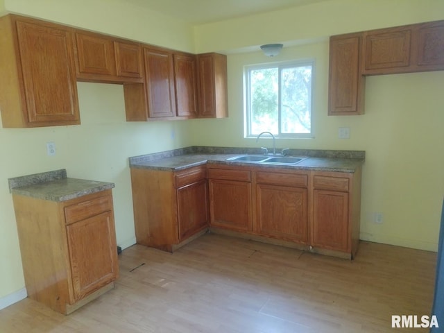 kitchen with sink and light hardwood / wood-style flooring