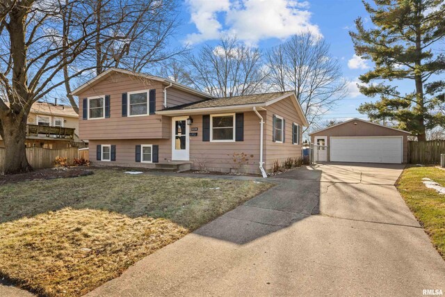 split level home featuring an outbuilding, a garage, and a front lawn