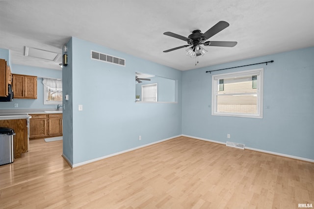 unfurnished room featuring sink, light hardwood / wood-style floors, and ceiling fan