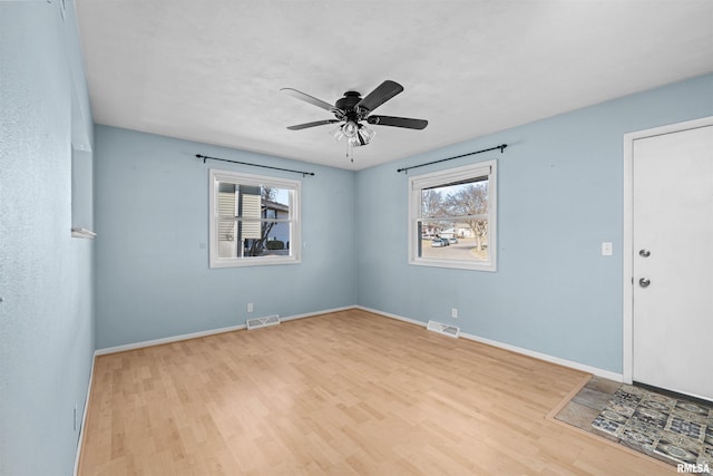 spare room featuring ceiling fan, a healthy amount of sunlight, and light hardwood / wood-style floors