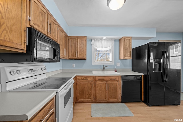 kitchen featuring light hardwood / wood-style floors, sink, and black appliances