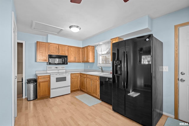 kitchen with light wood-type flooring, sink, and black appliances