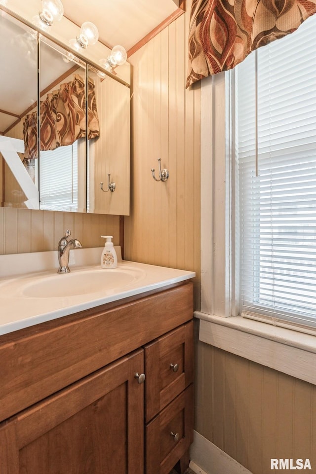 bathroom with vanity and wooden walls