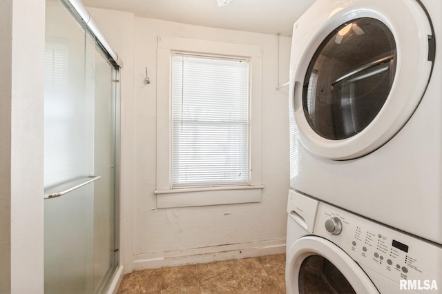 clothes washing area featuring stacked washer / drying machine