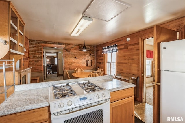 kitchen with brick wall, wooden walls, and white appliances