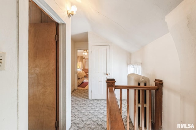 hall with vaulted ceiling and light colored carpet