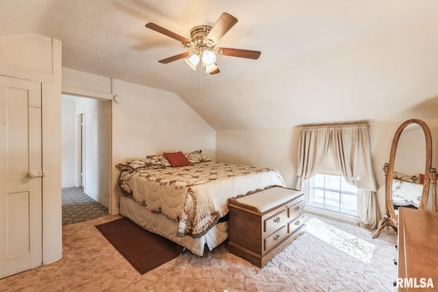 bedroom with lofted ceiling, light colored carpet, and ceiling fan