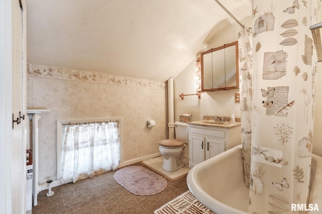 bathroom featuring lofted ceiling, toilet, a bath, and vanity