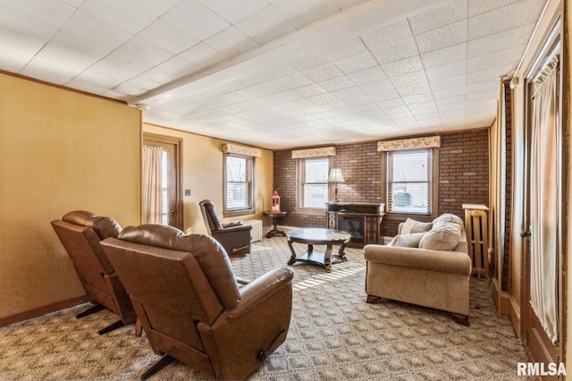 carpeted living room with brick wall and a healthy amount of sunlight