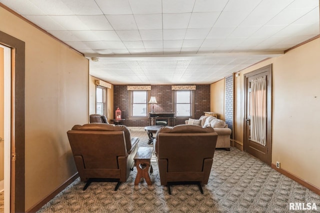 carpeted living room with brick wall and plenty of natural light