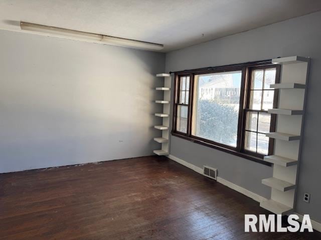 1615 Iowa Ave, Clinton, IA 52732 - spare room with dark wood-style flooring and baseboards